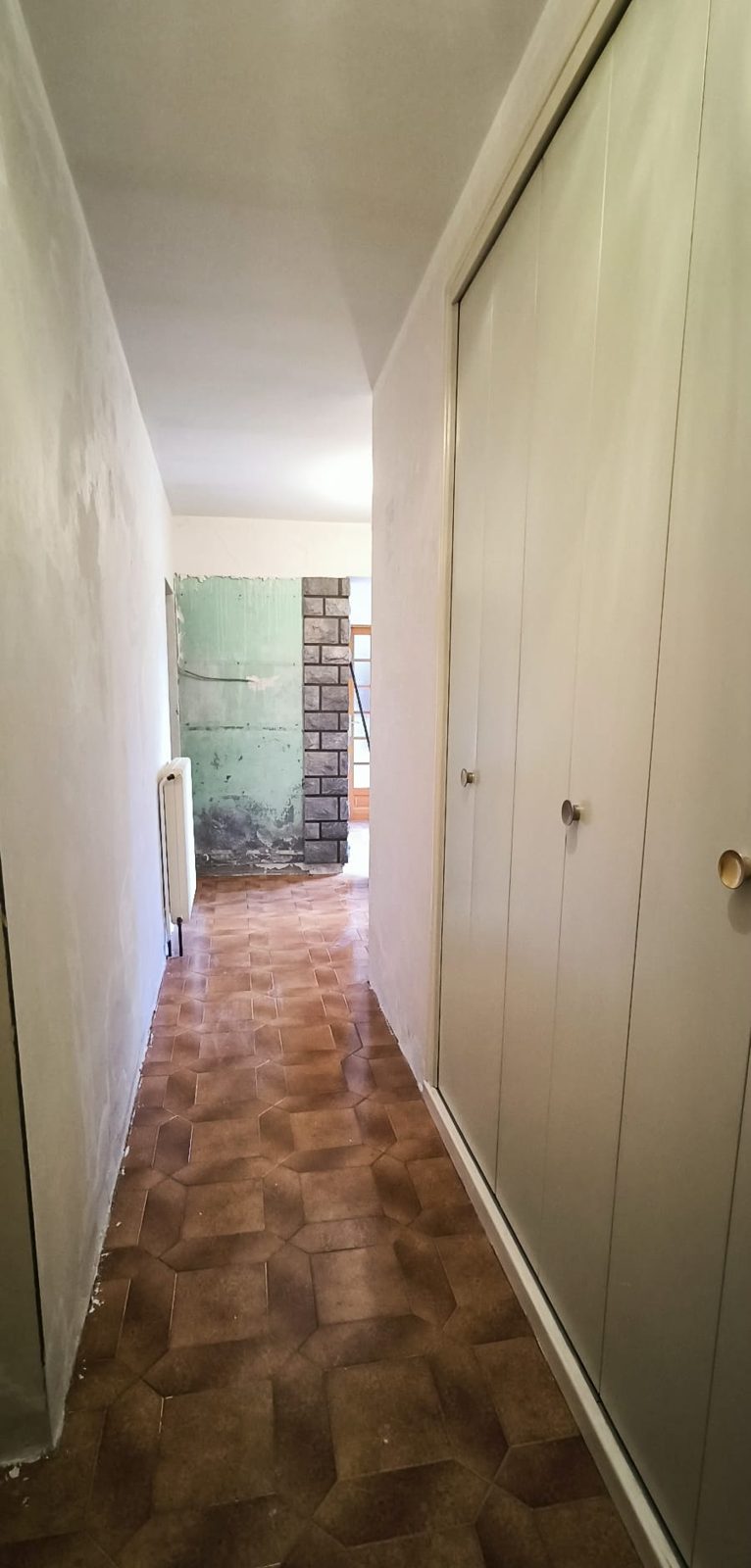 Avant travaux : couloir au carrelage ancien et aux murs abîmés