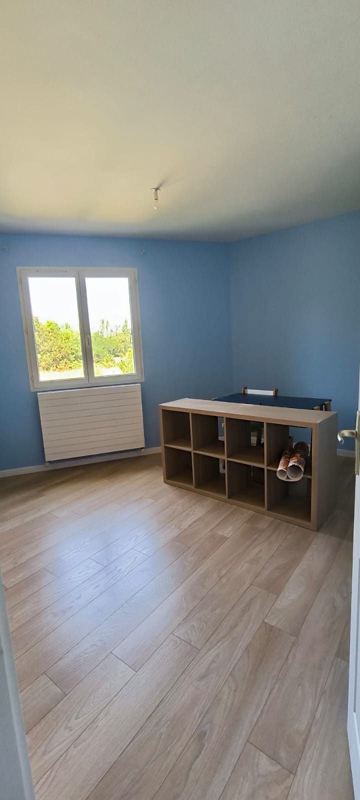 Chambre aux murs bleus avec un sol clair